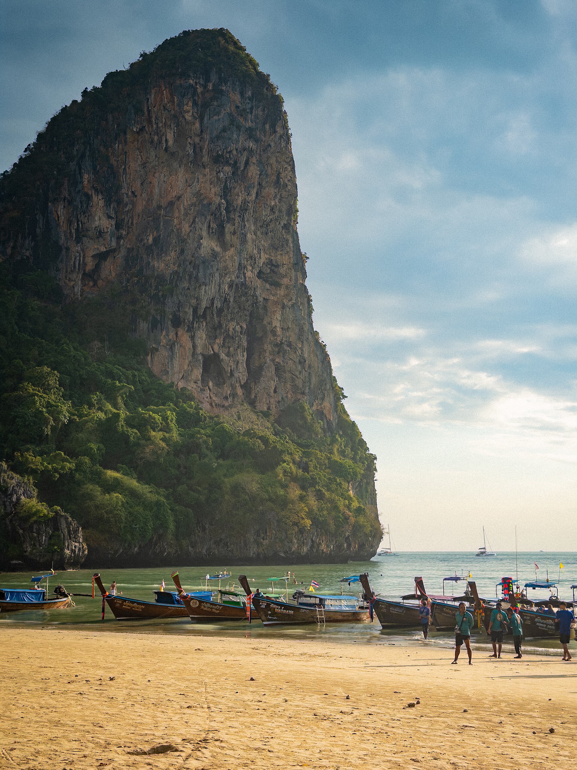 Longtail boats below limestone cliffs at Railay Beach, Krabi